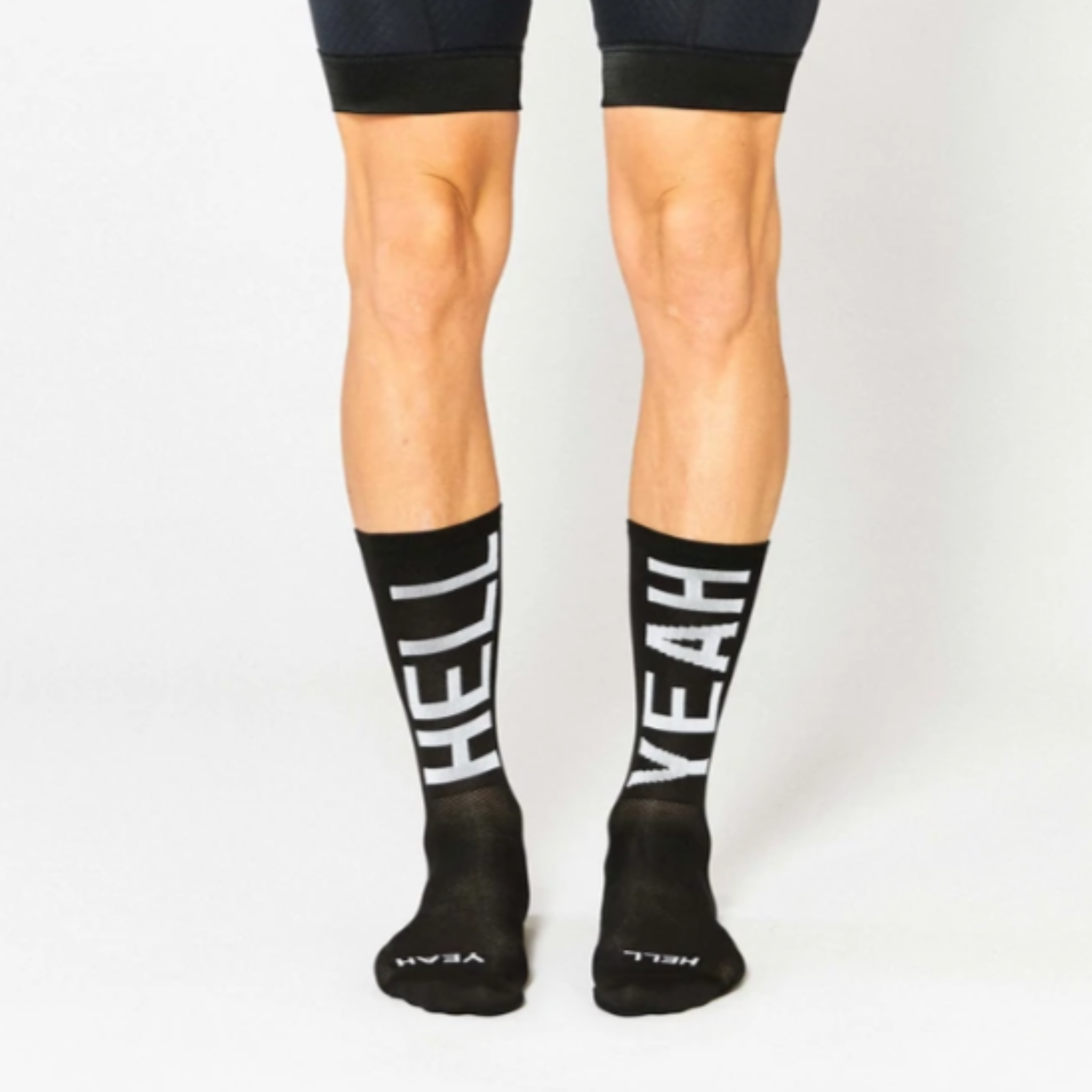 Cykelstrømpe i sort med hvid skrift, Hell Yeah. modellen hedder #666 hell yeah 2.0 og er fra Fingers Crossed