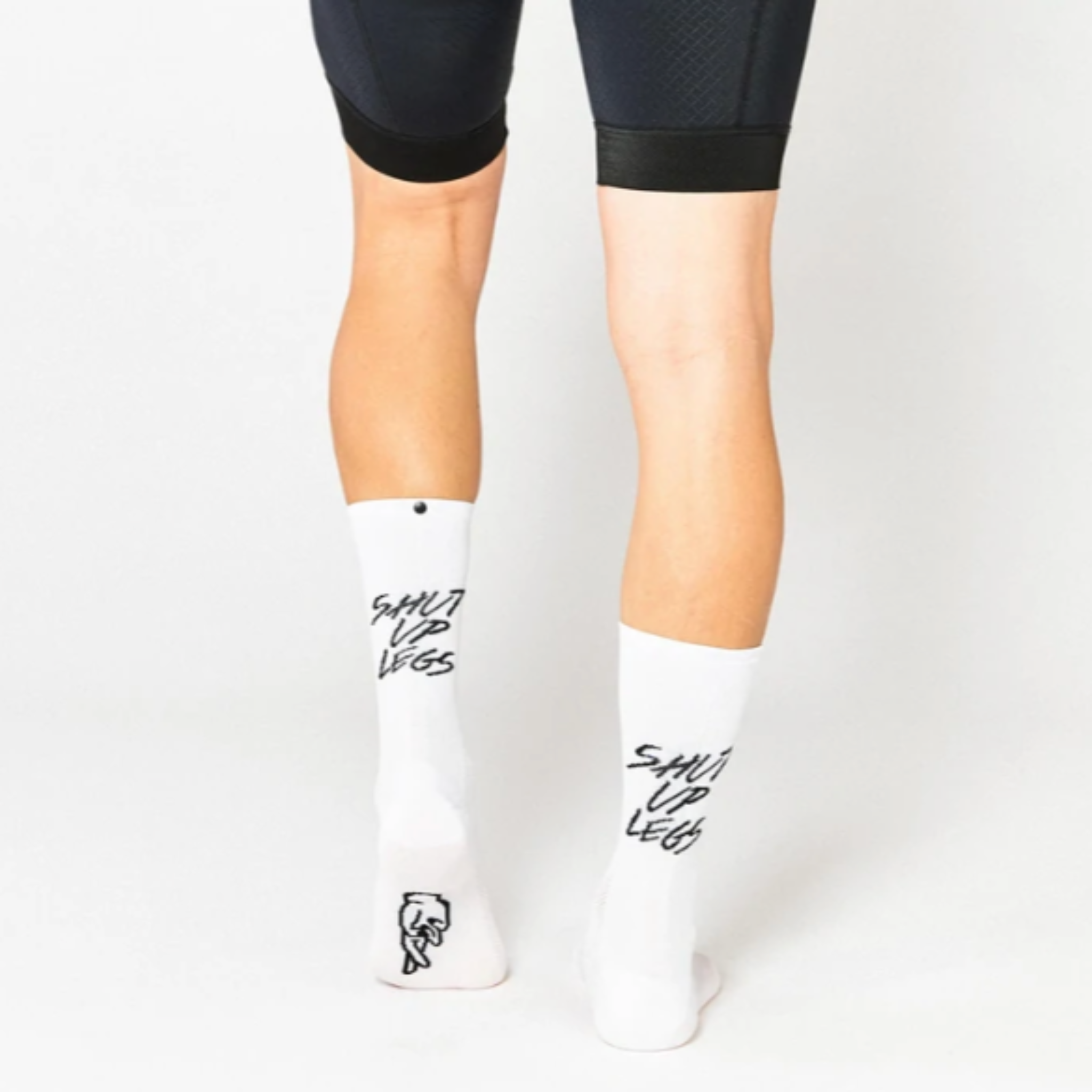 Fingers crossed cykelstrømpe. Hvid med sort tekst bagpå Shut up legs. 